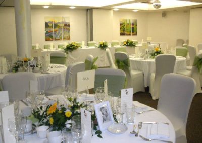 Yellow, white and green bespoke wedding flowers on reception tables by Shrinking Violet